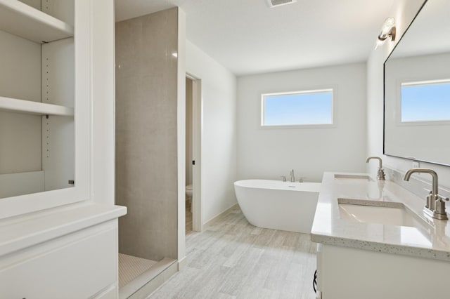 21959 Edison Ct NW, East Bethel, MN 55011 - full bath featuring double vanity, a tile shower, a freestanding bath, and wood finished floors