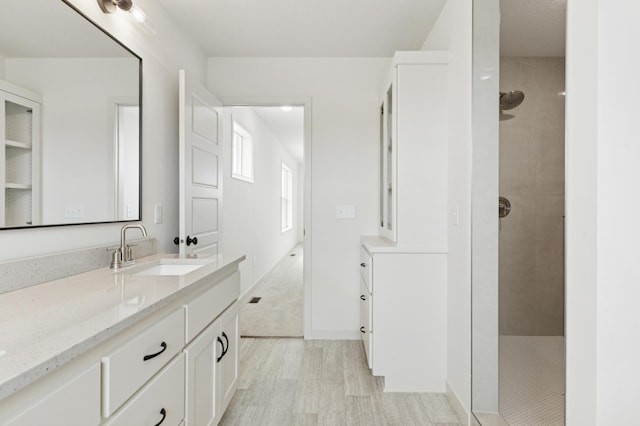 21959 Edison Ct NW, East Bethel, MN 55011 - bathroom with vanity, a tile shower, and wood finished floors