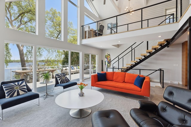 176 Peninsula Rd, Medicine Lake, MN 55441 - living room with a high ceiling, a water view, stairway, and a chandelier