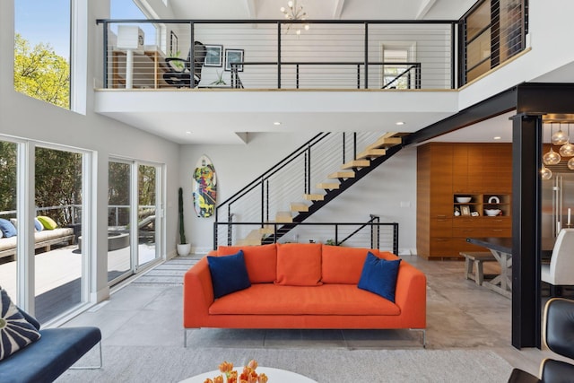 176 Peninsula Rd, Medicine Lake, MN 55441 - living room featuring a towering ceiling, stairs, and concrete floors