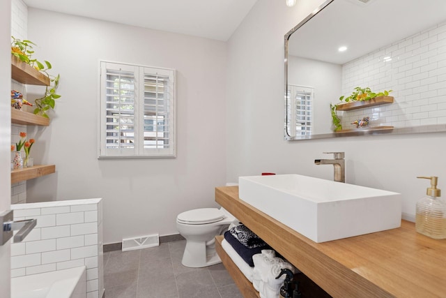 176 Peninsula Rd, Medicine Lake, MN 55441 - full bath featuring a sink, decorative backsplash, toilet, tile patterned floors, and a tub to relax in