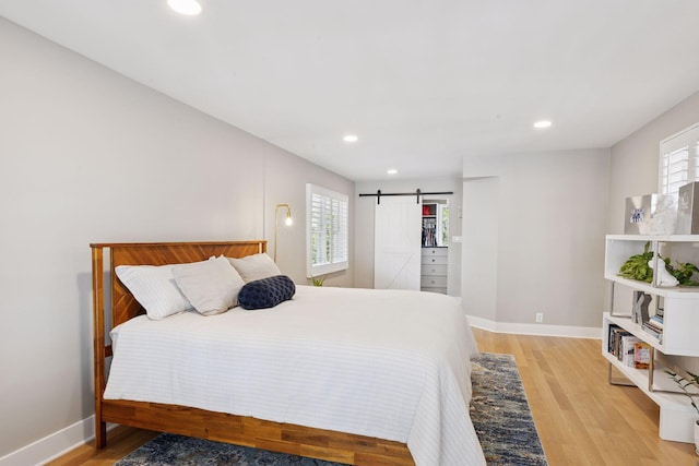 176 Peninsula Rd, Medicine Lake, MN 55441 - bedroom with a barn door, light wood-type flooring, recessed lighting, and baseboards