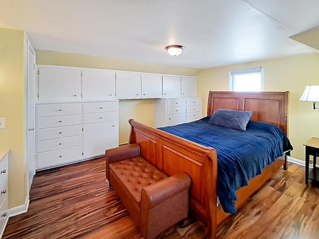 bedroom featuring baseboards and dark wood finished floors