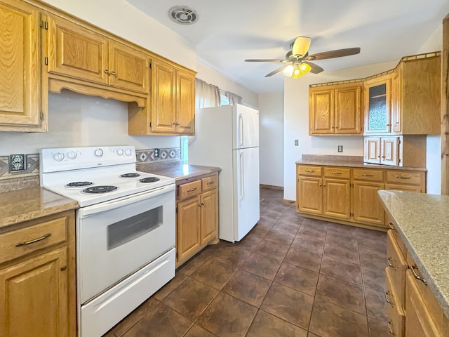 kitchen featuring plenty of natural light, a ceiling fan, dark tile patterned flooring, glass insert cabinets, and white appliances