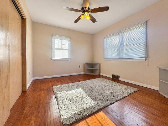 unfurnished bedroom featuring baseboards, a closet, hardwood / wood-style floors, and visible vents