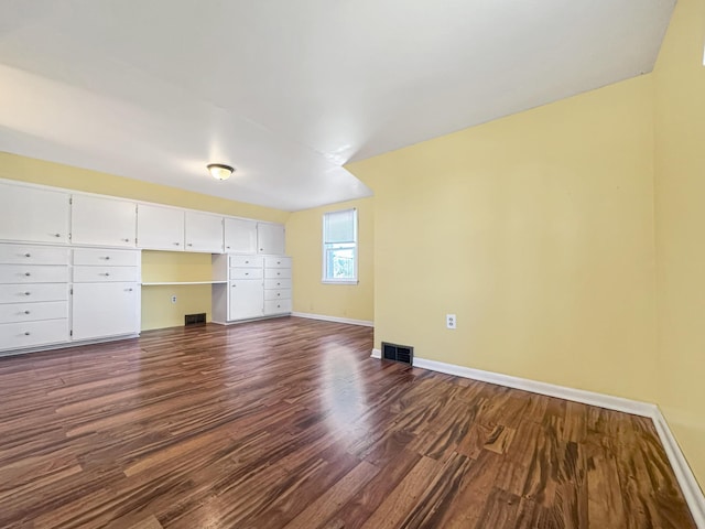 unfurnished living room with visible vents, dark wood-style flooring, and baseboards
