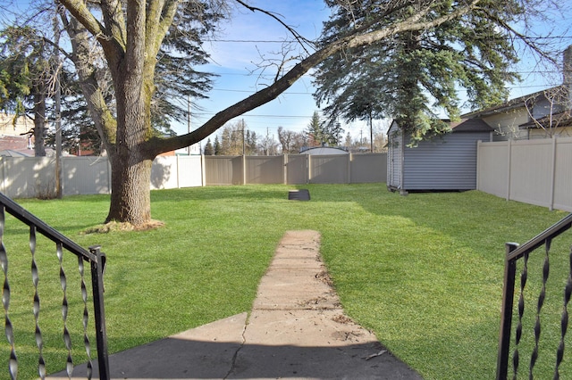 view of yard featuring an outdoor structure, a fenced backyard, and a storage shed