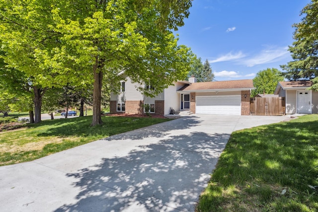 1112 Gabbert Cir, Eagan, MN 55123 - view of front of house with brick siding, concrete driveway, an attached garage, a chimney, and a gate