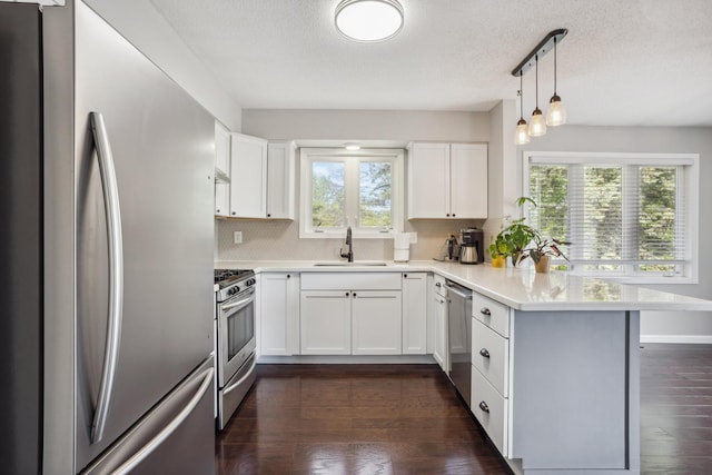 1112 Gabbert Cir, Eagan, MN 55123 - kitchen with appliances with stainless steel finishes, a peninsula, a sink, backsplash, and a textured ceiling
