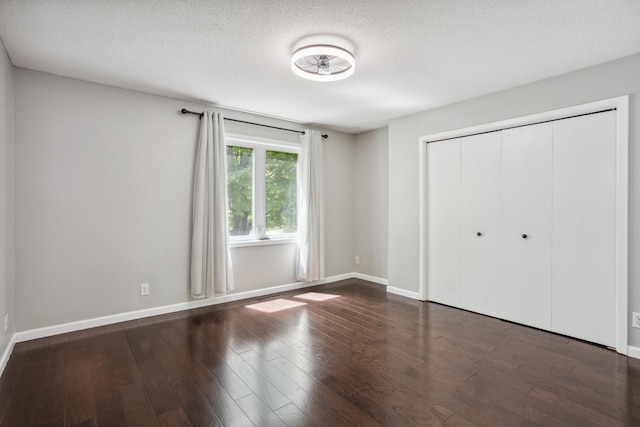 1112 Gabbert Cir, Eagan, MN 55123 - unfurnished bedroom featuring wood finished floors, a textured ceiling, a closet, and baseboards