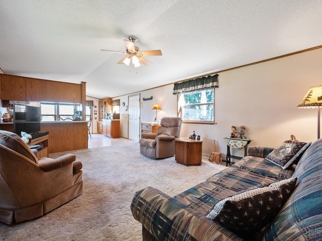 living room featuring light colored carpet, lofted ceiling, a textured ceiling, and a ceiling fan