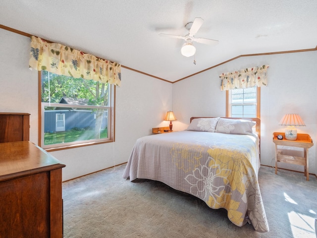 carpeted bedroom with vaulted ceiling, ornamental molding, baseboards, and a ceiling fan