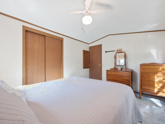 bedroom with ornamental molding, lofted ceiling, a closet, and a ceiling fan