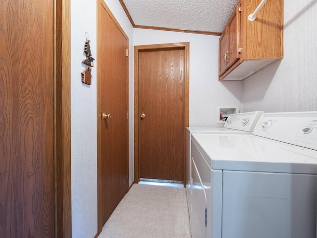 laundry room with a textured ceiling, independent washer and dryer, crown molding, and cabinet space