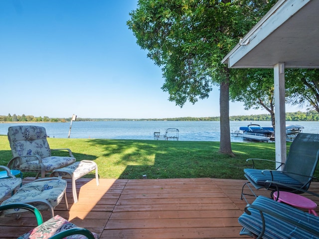 wooden terrace with a water view and a lawn