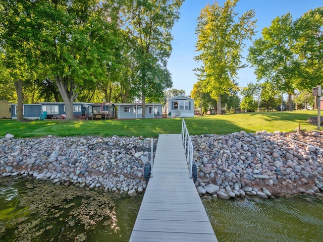 dock area featuring a lawn and a water view