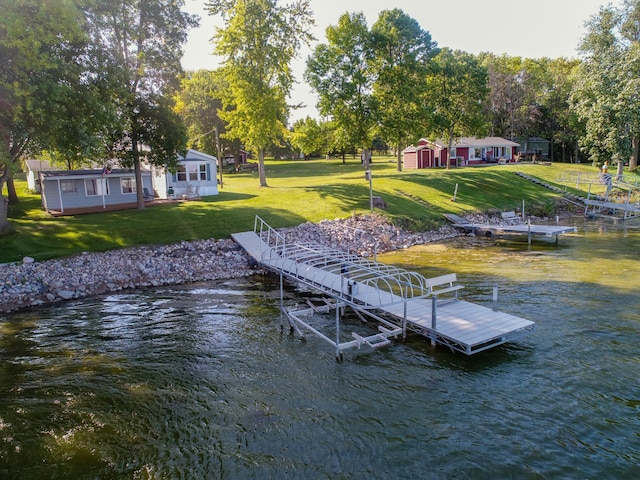 view of dock with a water view and a lawn