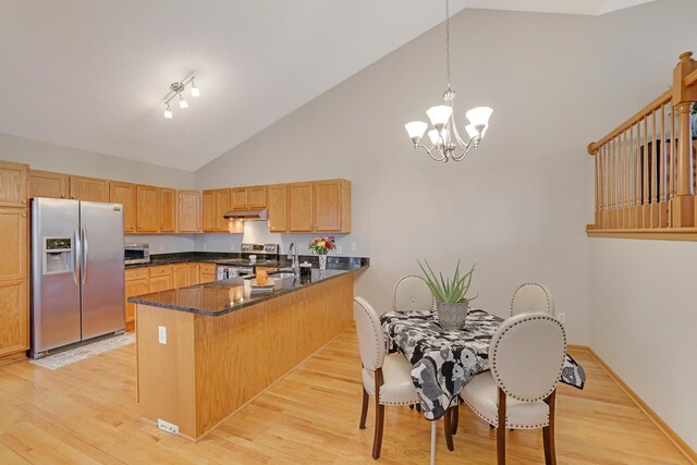 kitchen with stainless steel appliances, light wood-style floors, under cabinet range hood, a sink, and a peninsula