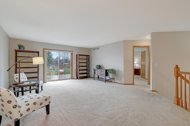 living area with an upstairs landing, visible vents, and carpet floors