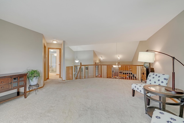 sitting room featuring an inviting chandelier, an upstairs landing, and carpet floors