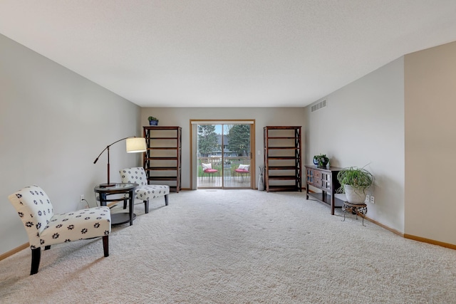 sitting room with visible vents, carpet flooring, and baseboards