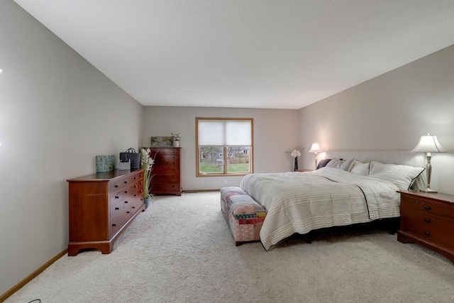 bedroom with baseboards and light carpet