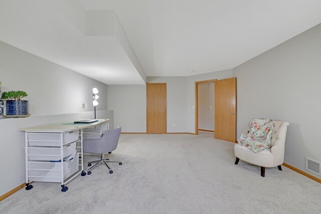 office area with baseboards, visible vents, and light colored carpet