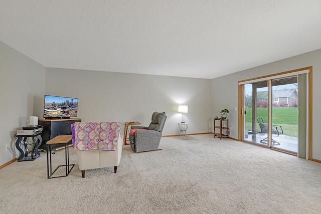 living area featuring carpet, a textured ceiling, and baseboards