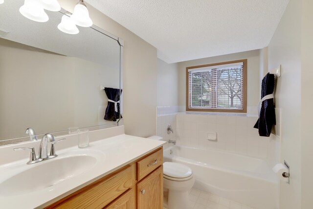 bathroom featuring toilet, a textured ceiling, a bathing tub, and vanity