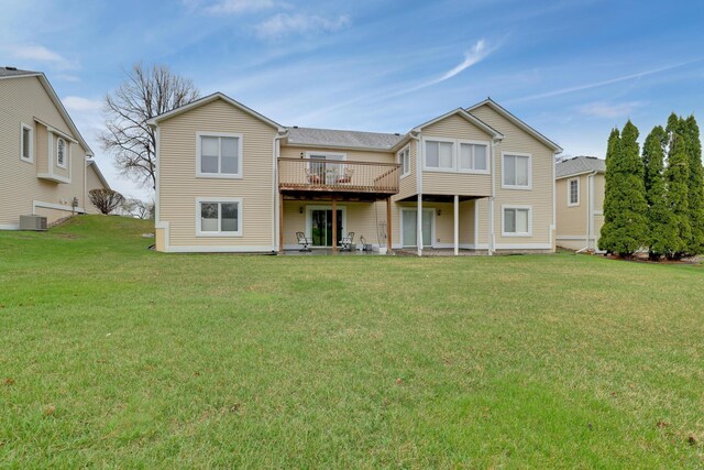 back of property featuring central AC, a wooden deck, and a lawn