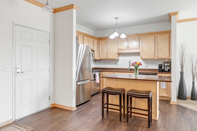 kitchen featuring appliances with stainless steel finishes, light brown cabinetry, dark wood-style flooring, a kitchen island, and a kitchen breakfast bar