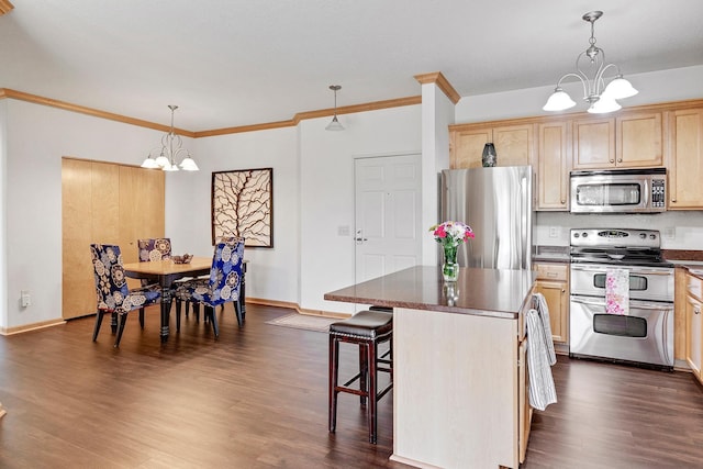 kitchen with appliances with stainless steel finishes, a chandelier, dark countertops, dark wood-style floors, and crown molding