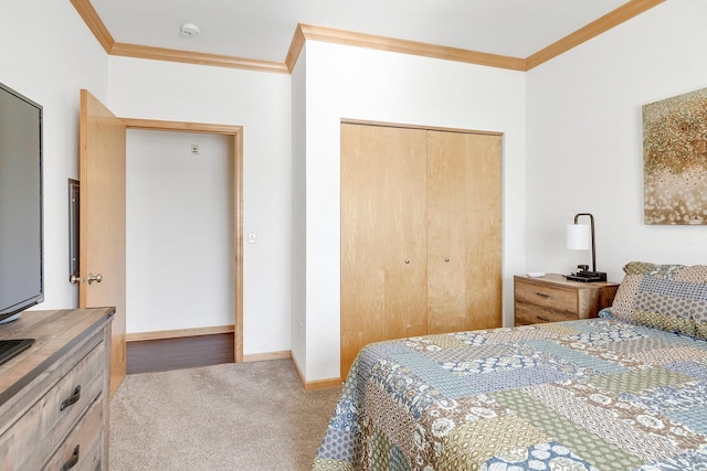 carpeted bedroom with ornamental molding, a closet, and baseboards