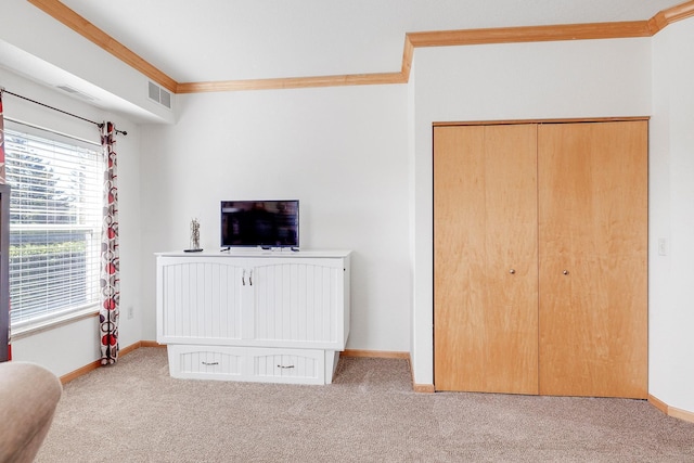 bedroom with carpet, crown molding, baseboards, and a closet