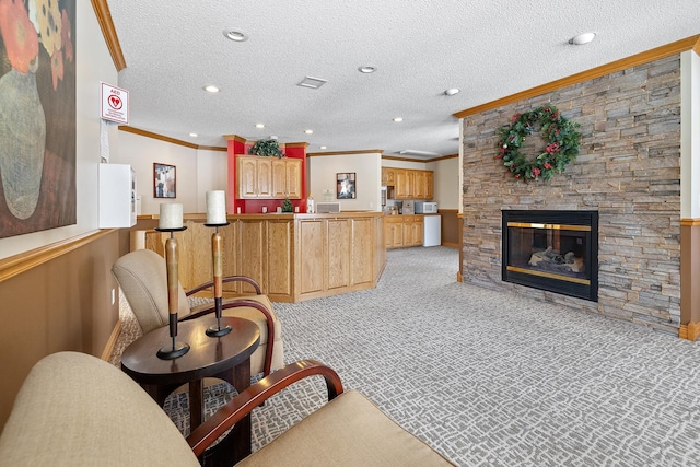 living area featuring ornamental molding, light colored carpet, a stone fireplace, and a textured ceiling