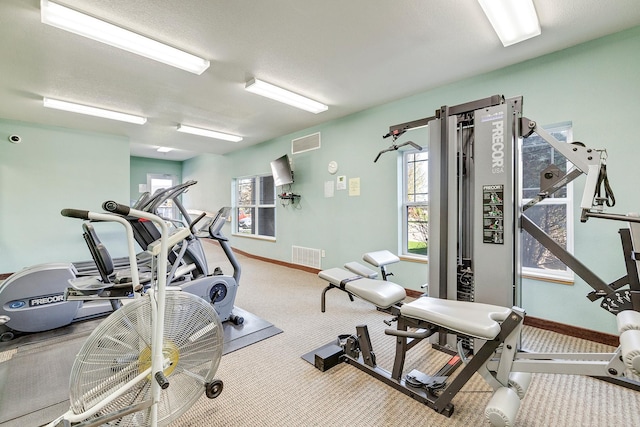 exercise room featuring carpet floors and baseboards