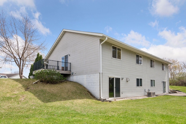 back of property featuring a lawn, central air condition unit, and a wooden deck