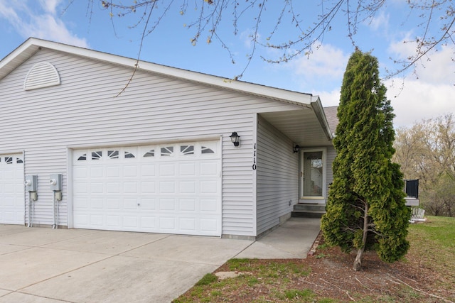 view of side of property featuring concrete driveway and an attached garage