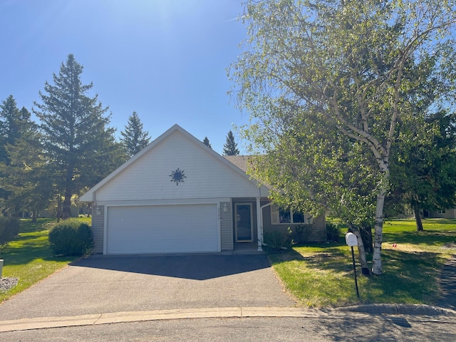 ranch-style house featuring an attached garage, driveway, and a front lawn