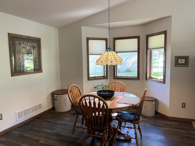 dining area featuring dark wood finished floors, baseboards, and vaulted ceiling