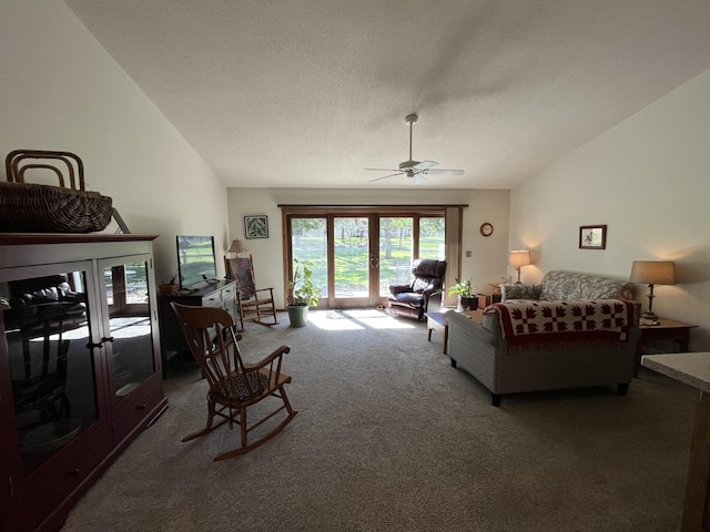 living area featuring carpet flooring, a ceiling fan, and vaulted ceiling