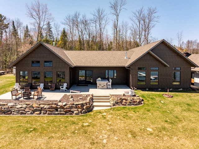 back of house featuring an outdoor fire pit, a patio area, roof with shingles, and a yard