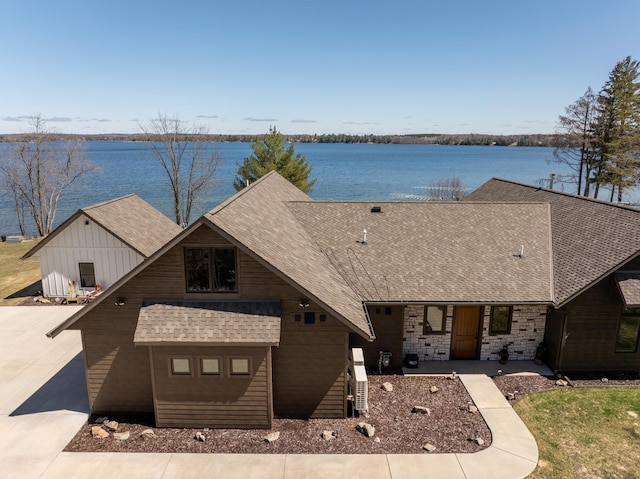 view of front of house with a water view and a shingled roof