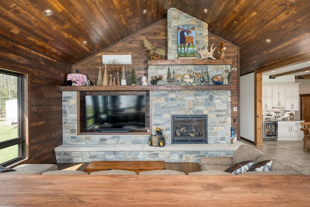 living area with wood walls, wooden ceiling, vaulted ceiling, a fireplace, and beverage cooler