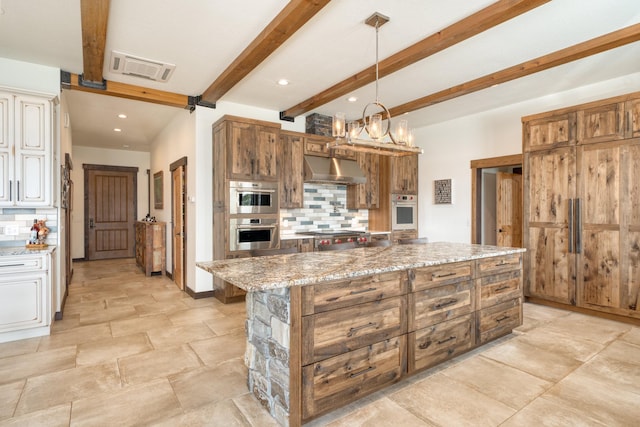 kitchen with double oven, beamed ceiling, under cabinet range hood, decorative backsplash, and light stone counters