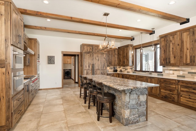 kitchen with washer / dryer, appliances with stainless steel finishes, tasteful backsplash, and recessed lighting