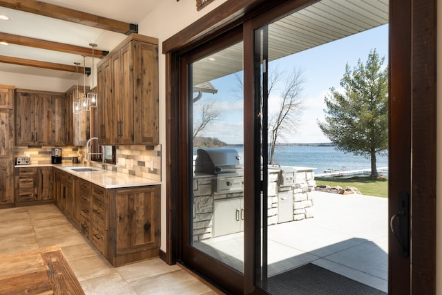 doorway featuring a wealth of natural light, light tile patterned floors, a water view, and a sink