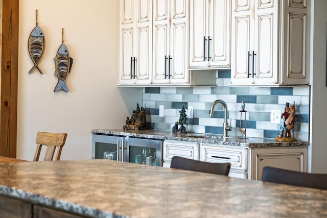 kitchen with a sink, tasteful backsplash, and dark countertops