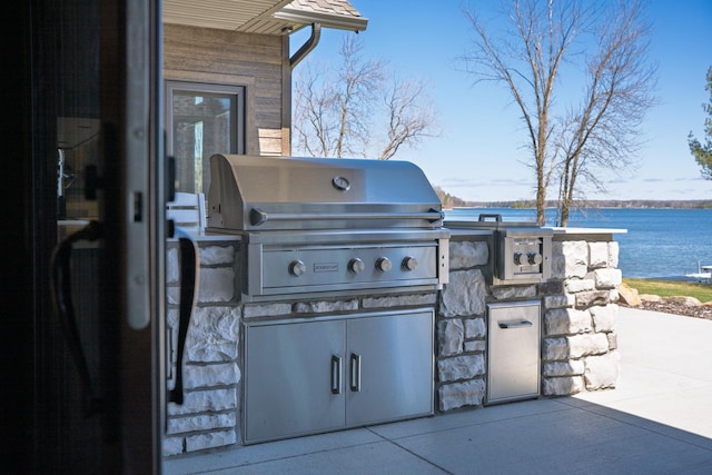 view of patio / terrace featuring a water view, area for grilling, and a grill