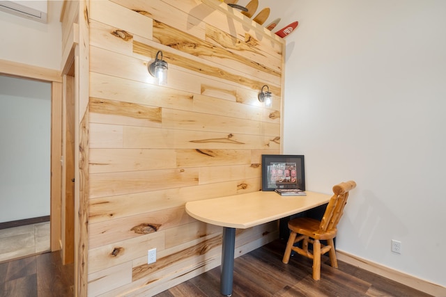 home office with a wall mounted air conditioner, wood walls, dark wood-style flooring, and baseboards